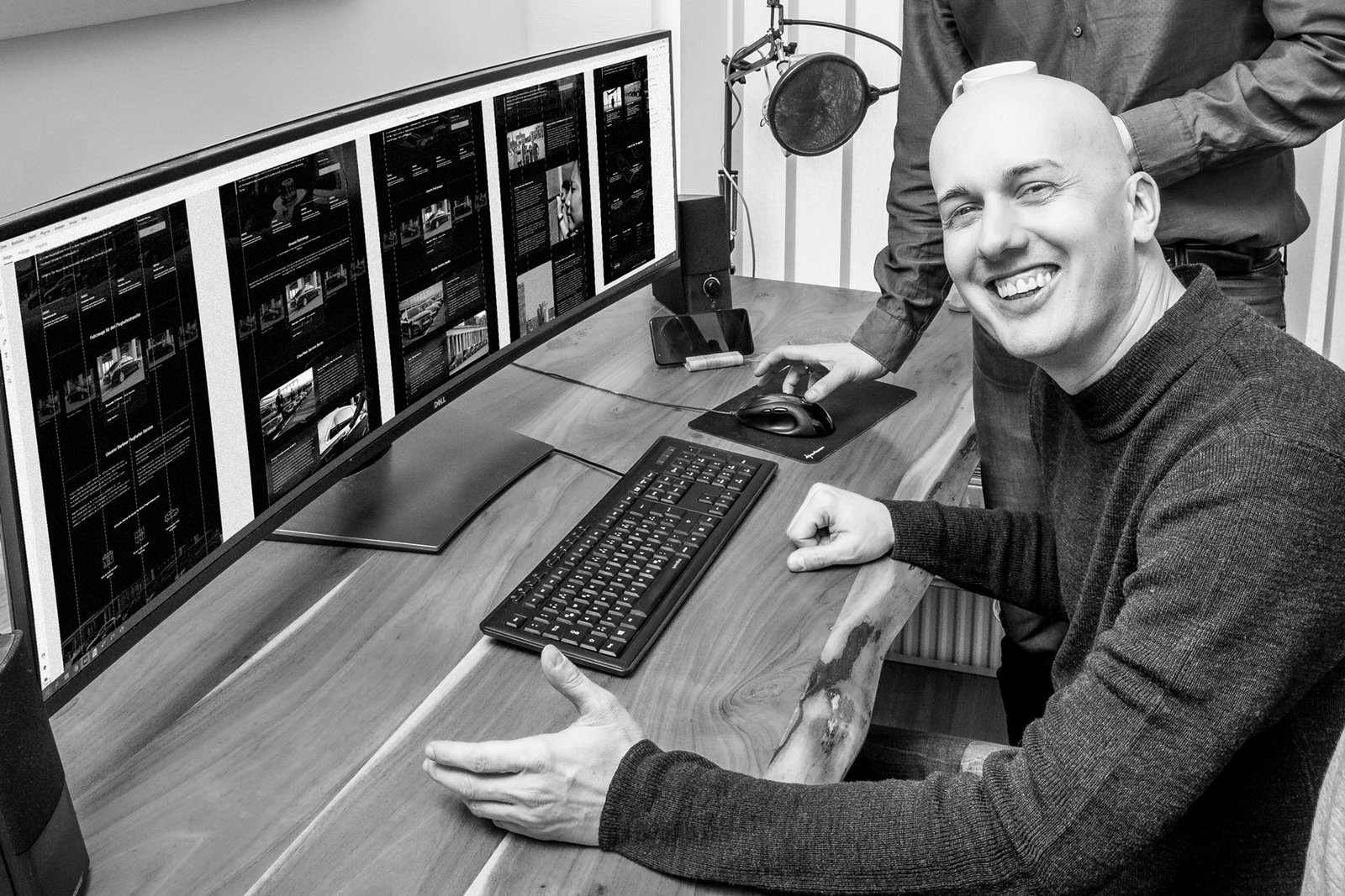 Csongor working through a layout across a wide monitor with a colleague